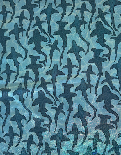 Pattern of shark silhouettes on a blue textured background