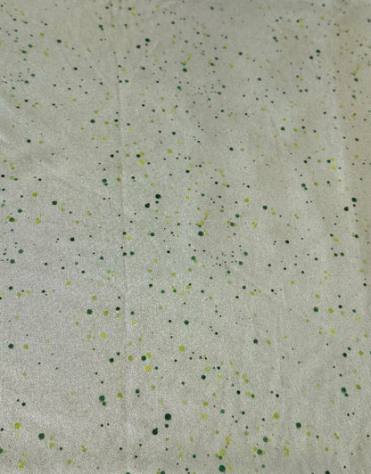 Textured fabric with small speckles on a light green background