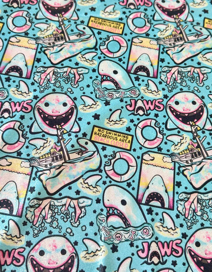 Colorful pattern with cartoon sharks and 'Jaws' text on a blue background